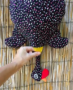 a person holding a banana next to a stuffed animal on a wicker table cloth