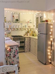 the kitchen is decorated with christmas lights and garlands on the wall above the refrigerator