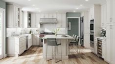 a large kitchen with white cabinets and wooden flooring, along with an island in the middle