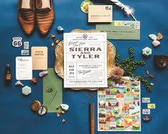 the wedding stationery is laid out neatly on top of the blue tablecloth, including shoes and other items