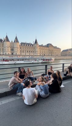 several people sitting on the side of a bridge