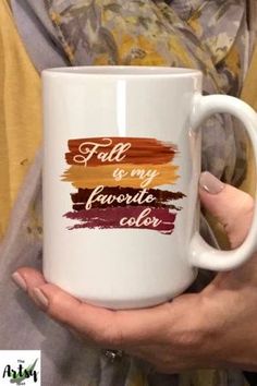 a woman holding a coffee mug with the words fall and my favorite color on it