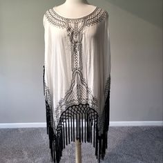 Chico’s White/Black Drama Fringe Top/Poncho (Size L/Xl). This Dramatic Showstopper Will Turn Heads In Any Room. Sport It Over Black Or White Slacks Or Even A Solid Black Or White Tank Dress You Decide. Top Is 42-1/2” In Length From Top Of Shoulder To The Longest Point Of Fringe. 100% Rayon/Viscosa. Hand Wash Cold Separately. Only Non-Chlorine Bleach When Needed. Line Dry. Cool Iron As Needed. May Be Dry Cleaned. New With Tags. Oversized Black Summer Poncho, Black Poncho For Summer, Black Batwing Sleeve Poncho For Spring, Black Bohemian Poncho With Batwing Sleeves, Chic One Size Beach Cover-up Top, Chic Summer Cape Tops, One Size Fringe Tops For Spring, Chic Summer Poncho In Cape Style, Chic Summer Cape Poncho