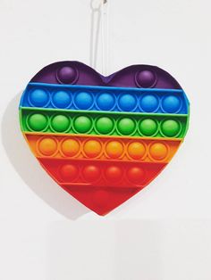 a colorful heart shaped ornament hanging on a wall