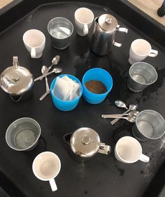 there are many cups and spoons on the tray