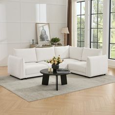 a living room with white furniture and wood floors