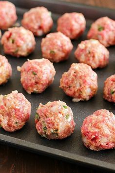 raw meatballs on a baking sheet ready to be cooked in the oven for consumption