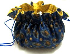 a small blue bag with yellow flowers on it's side and a string around the bottom