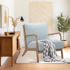 a blue chair sitting on top of a hard wood floor next to a wooden table