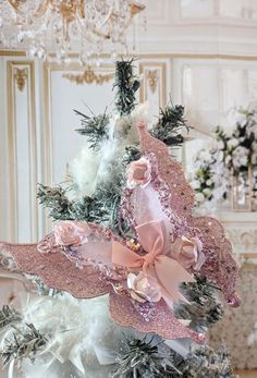 a christmas tree decorated with pink and white ribbons