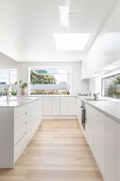 an image of a kitchen setting with white cabinets and wood flooring in the middle