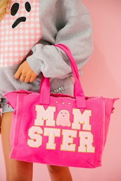 Get ready to be the life of the trick or treating party with our Momster Pink Tote Bag! Carry all the candy you could ever want and show off your playful side with our pink ghost patch! All orders are currently shipping within 14 business days. To receive item quicker, expedited shipping is available at checkout. **ALL HALLOWEEN ORDERS MUST BE PLACED WITH EXPEDITED SHIPPING TO GUARANTEE DELIVERY BY OCT. 31 IF PLACED AFTER OCT. 15** Playful Pink Large Capacity Bags, Playful Large Capacity Pink Bags, Playful Pink Cotton Bag, Playful Pink Bags For Everyday Use, Playful Pink Bag For Everyday Use, Pink Cotton Bag With Double Handle, Playful Pink Everyday Bag, Playful Pink Everyday Bags, Fun Pink Cotton Bag