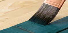 a close up of a paint brush on a wooden floor