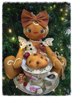 a teddy bear sitting on top of a teacup filled with cookies and other treats