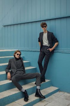 two men in suits sitting on some steps