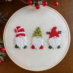 three gnomes in red and white hats are on the embroidery