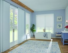 a large bathroom with blue walls and white trim on the doors, windows, and rug