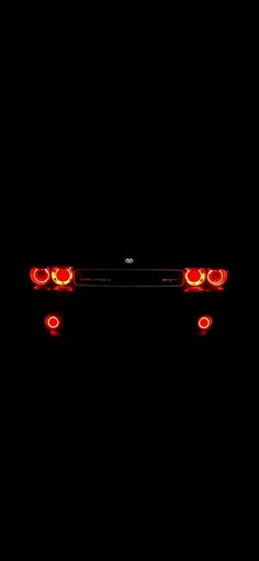 the tail lights of a car are glowing red in the dark, and there is no image here to provide a caption for