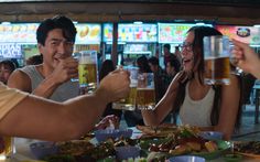 people sitting at a table drinking beer and eating food