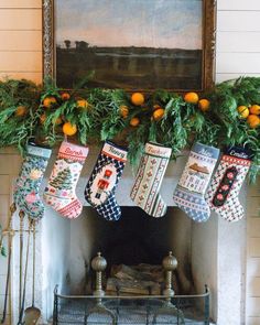 stockings hanging from the mantel in front of an old fireplace with oranges on it