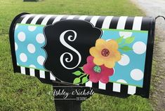 a black and white polka dot mailbox with a flower on it's front