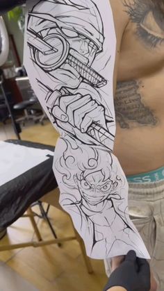 a man with tattoos on his arm holding up a piece of paper