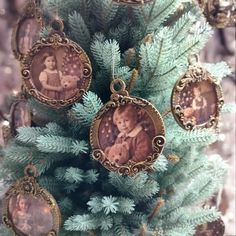 an ornament hanging from the top of a christmas tree decorated with family photos