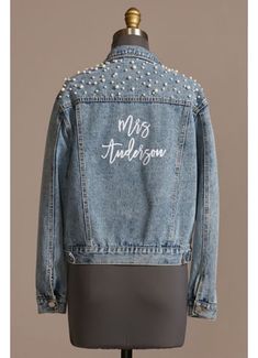 a jean jacket that says mrs anderson on the front and back, with pearls in it