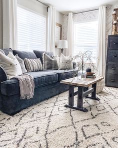 a living room filled with furniture and pillows on top of a white carpeted floor