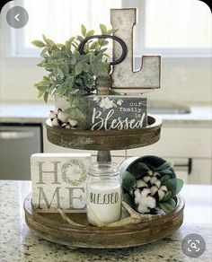 three tiered tray with flowers and letters on it