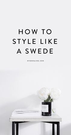 a vase with flowers sitting on top of a table next to a white wall and the words how to style like a swede