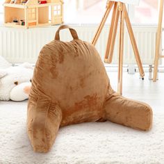 a large stuffed animal laying on the floor next to a teddy bear and easel