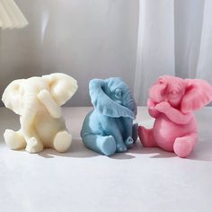 three small elephant figurines sitting next to each other