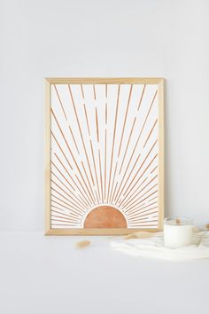 a white wall with a wooden frame on it and a candle in front of it