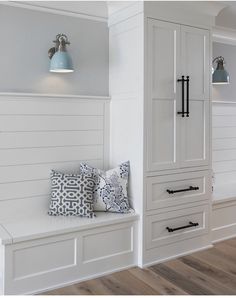 a room with white walls and wood flooring, two blue lamps on the wall