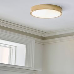 a light that is on above a window in a room with white walls and trim