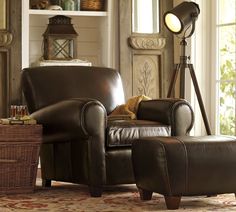 a brown leather chair and foot stool in a living room