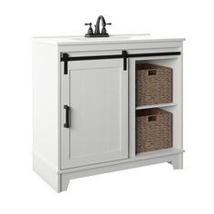 a white cabinet with two baskets under it and a faucet on the side