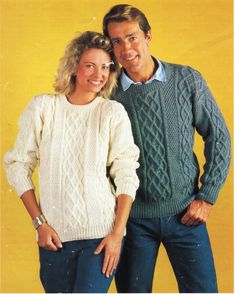 a man and woman in sweaters standing next to each other