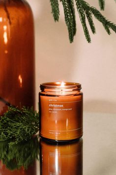 a candle sitting next to a brown bottle