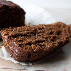 two pieces of chocolate cake sitting on top of paper