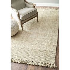 a chair sitting on top of a wooden floor next to a white chair and rug