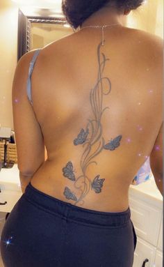 the back of a woman's body with butterflies on it