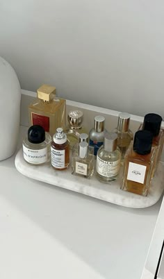 an assortment of perfumes on a white tray