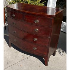 an old chest of drawers sitting on the sidewalk