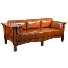 a brown leather couch sitting on top of a wooden table