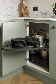 an open cabinet with plates and bowls in it