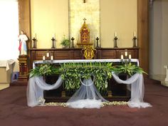 the altar is decorated with greenery and candles