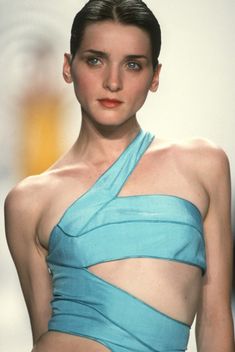 a woman in a blue dress on the runway