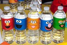 sesame street water bottles are lined up on a table